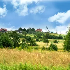 Zielone wzgórza z domami, idealne miejsce by sprawdzić czy działka jest budowlana.