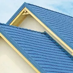 Dwa niebieskie dachy z blachy falistej, widoczne od strony ściany szczytowej, z żółtymi elementami wykończeniowymi.