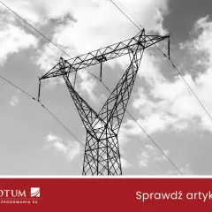 Wysoki słup energetyczny na działce, z liniami przesyłowymi na tle chmur.
