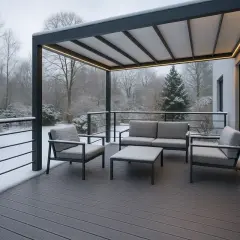 Nowoczesna deska kompozytowa montaż bez legarów na tarasie z meblami, otoczonym zimowym ogrodem.