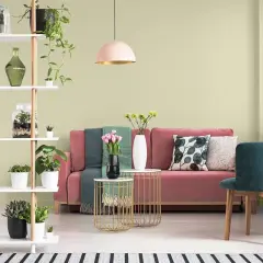 Salon z różową kanapą i zielonymi akcentami. Oliwkowa zieleń ścian tworzy spokojną atmosferę.