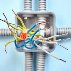 Instalacja elektryczna bezpuszkowa z kolorowymi przewodami i pomarańczowym złączem.