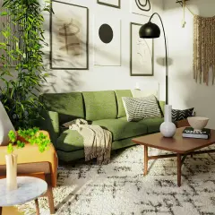 Zielona kanapa w salonie inspiracje: nowoczesny salon z zieloną kanapą, roślinami i sztuką na ścianach.