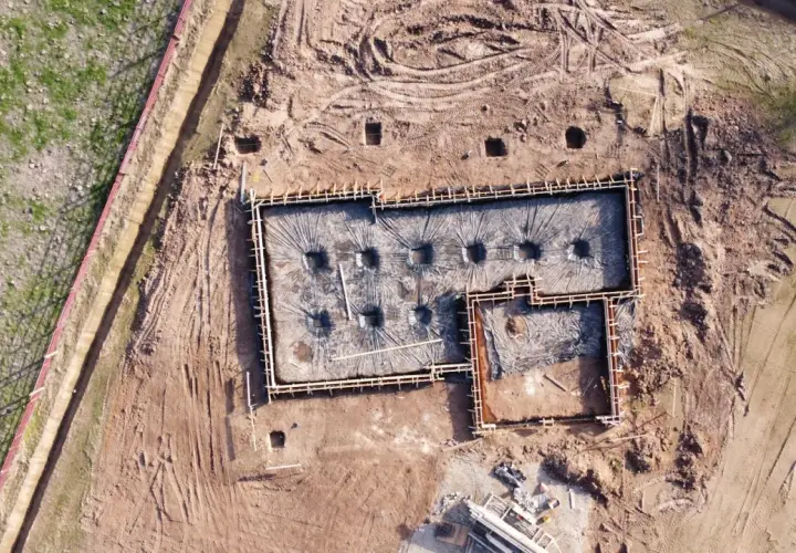 Fundamenty domu w trakcie budowy, przygotowane do zalania betonem. Widać zbrojenie i folię izolacyjną. Dobre odwodnienie domu to klucz do jego trwałości.
