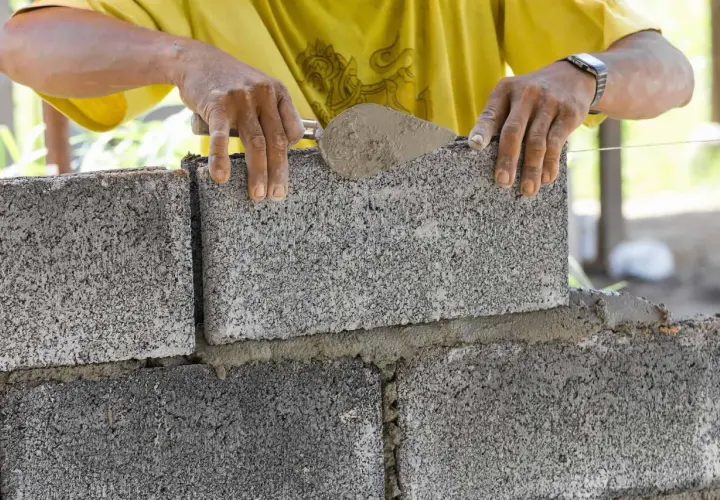 Budowniczy układa bloczki betonowe fundamentowe, tworząc solidną podstawę.