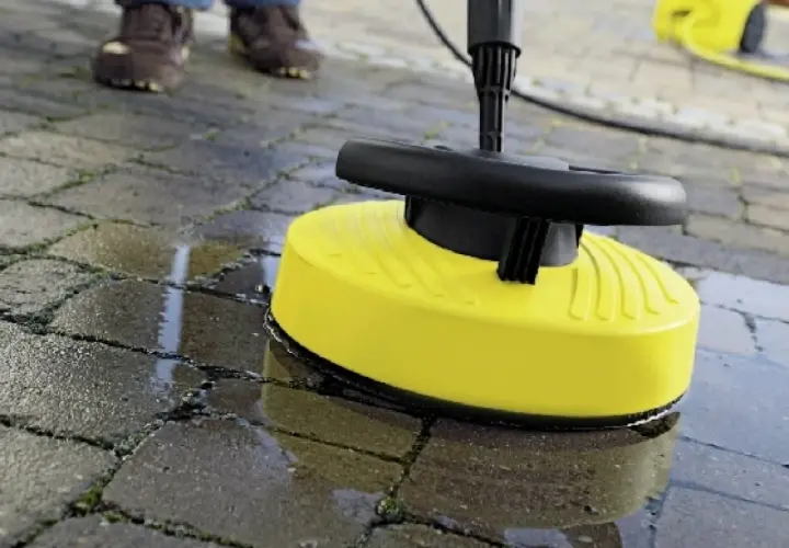 Żółta nakładka do myjki ciśnieniowej czyści kostkę brukową, usuwając brud i mech.