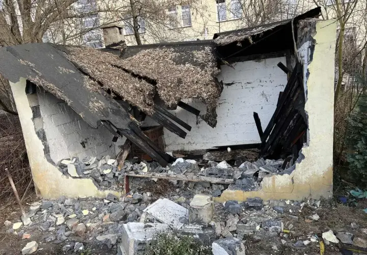 Zniszczony budynek, dach się zawalił, gruzy na ziemi. Trwa rozbiórka.