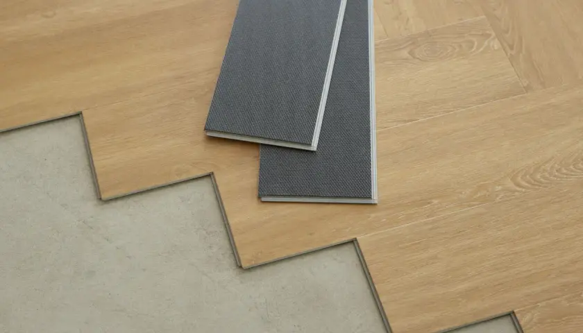 Panele winylowe imitujące drewno czekają na ułożenie na betonowej podłodze. Zobacz, jak kłaść panele krok po kroku.
