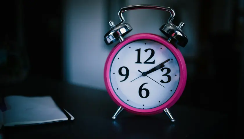 Różowy budzik na stoliku przypomina o ciszy nocnej w bloku. Zegar wskazuje późną godzinę, gdy wszyscy powinni już spać.