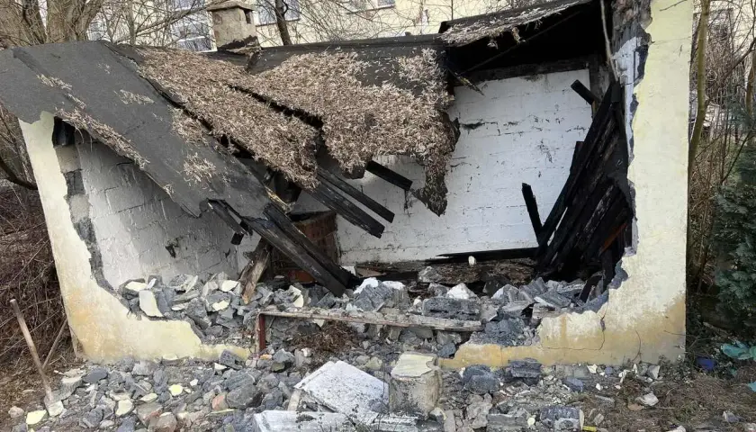 Zniszczony budynek, dach się zawalił, gruzy na ziemi. Trwa rozbiórka.