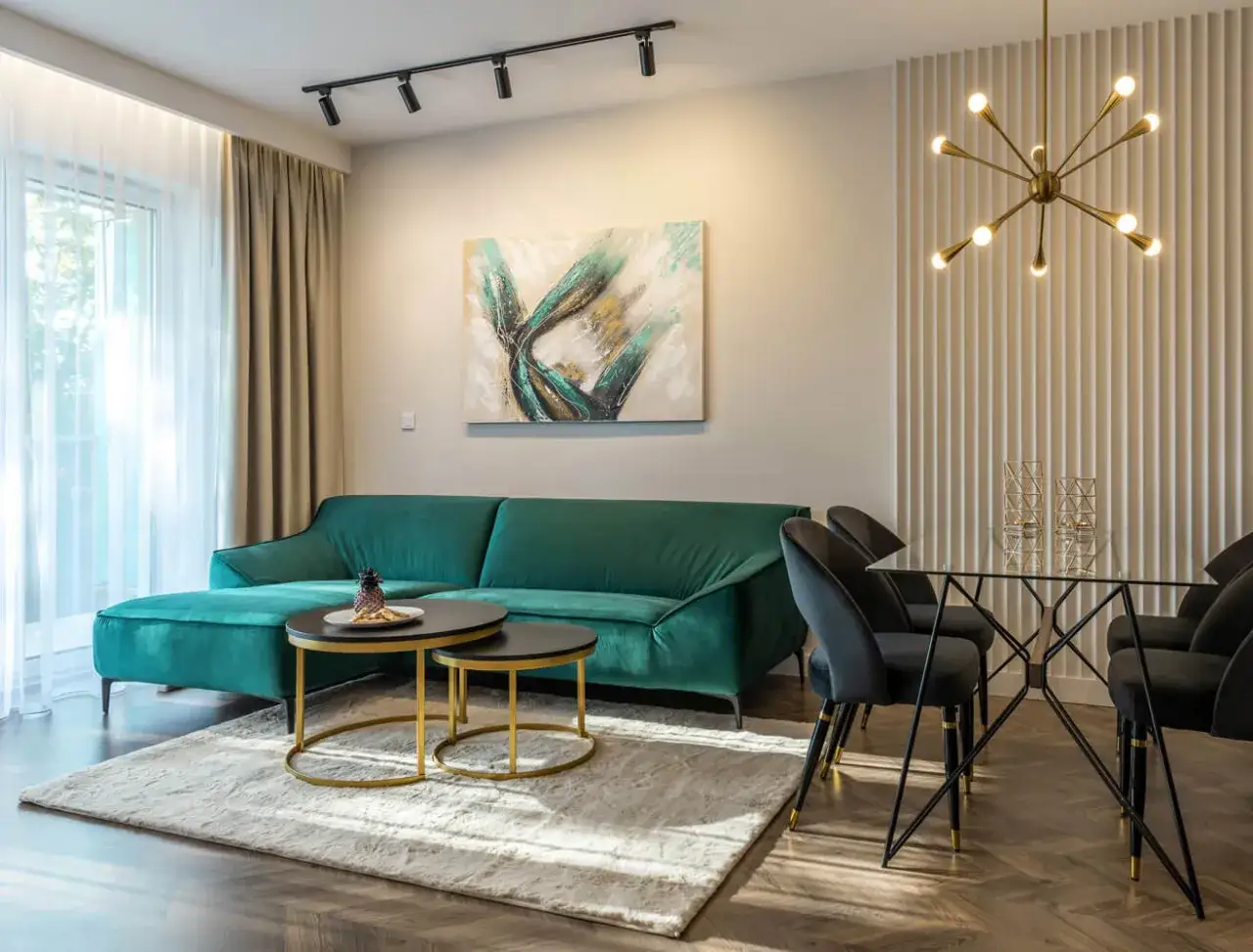 Nowoczesny salon z aksamitną, zieloną kanapą. Inspiracje dla Twojego wnętrza: elegancka jadalnia, sztuka na ścianie i designerskie oświetlenie.