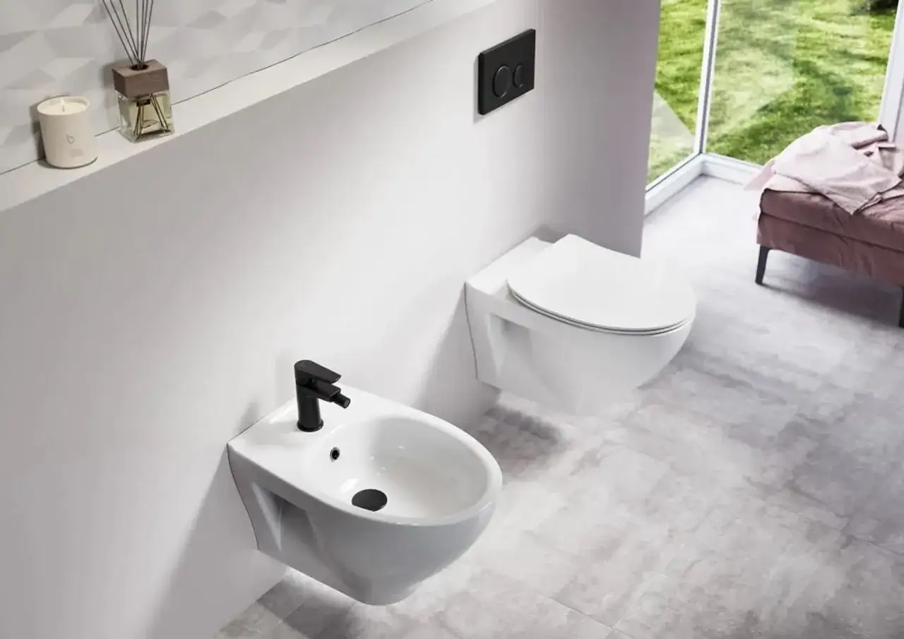 Nowoczesna łazienka z podwieszanym bidetem i toaletą. Czarna armatura dodaje elegancji. Zastanawiasz się, bidet co to? To urządzenie do higieny intymnej.