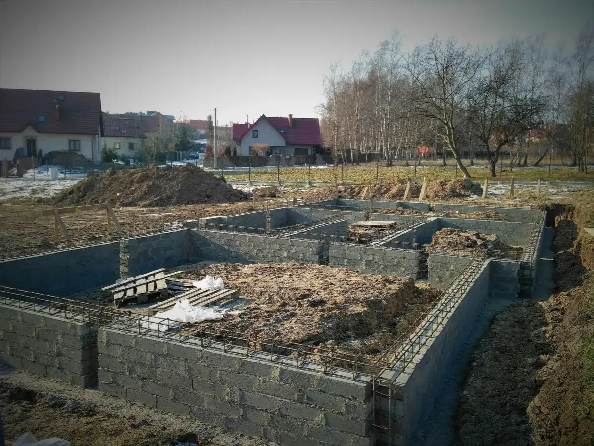 Fundament z bloczków betonowych, gotowy do zalania. Widać zbrojenie, przygotowane pod wylanie betonu na fundament.