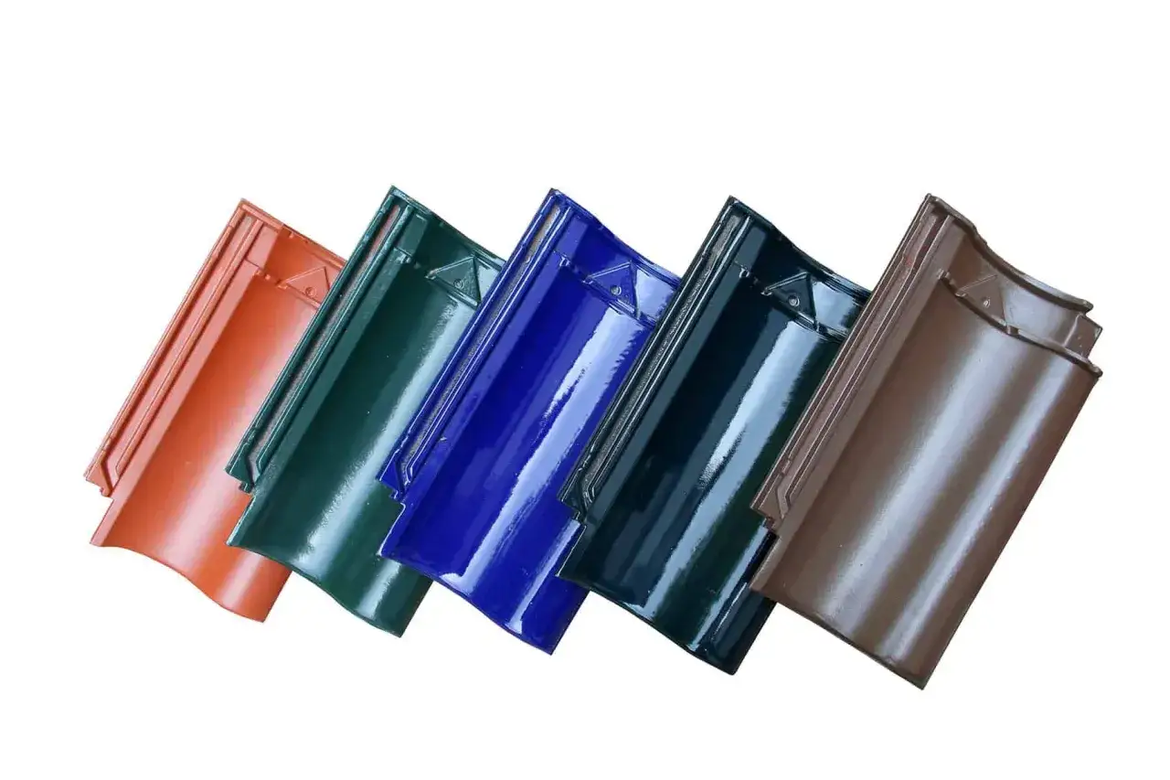 Pięć błyszczących dachówek ceramicznych w różnych kolorach: rudy, zielony, niebieski, granatowy i brązowy. Sprawdź dachówka ceramiczna cena za m2.